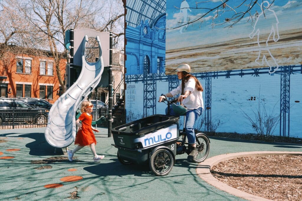 Photo d'une femme dans un parc pour enfant avec un vélo-cargo MULO