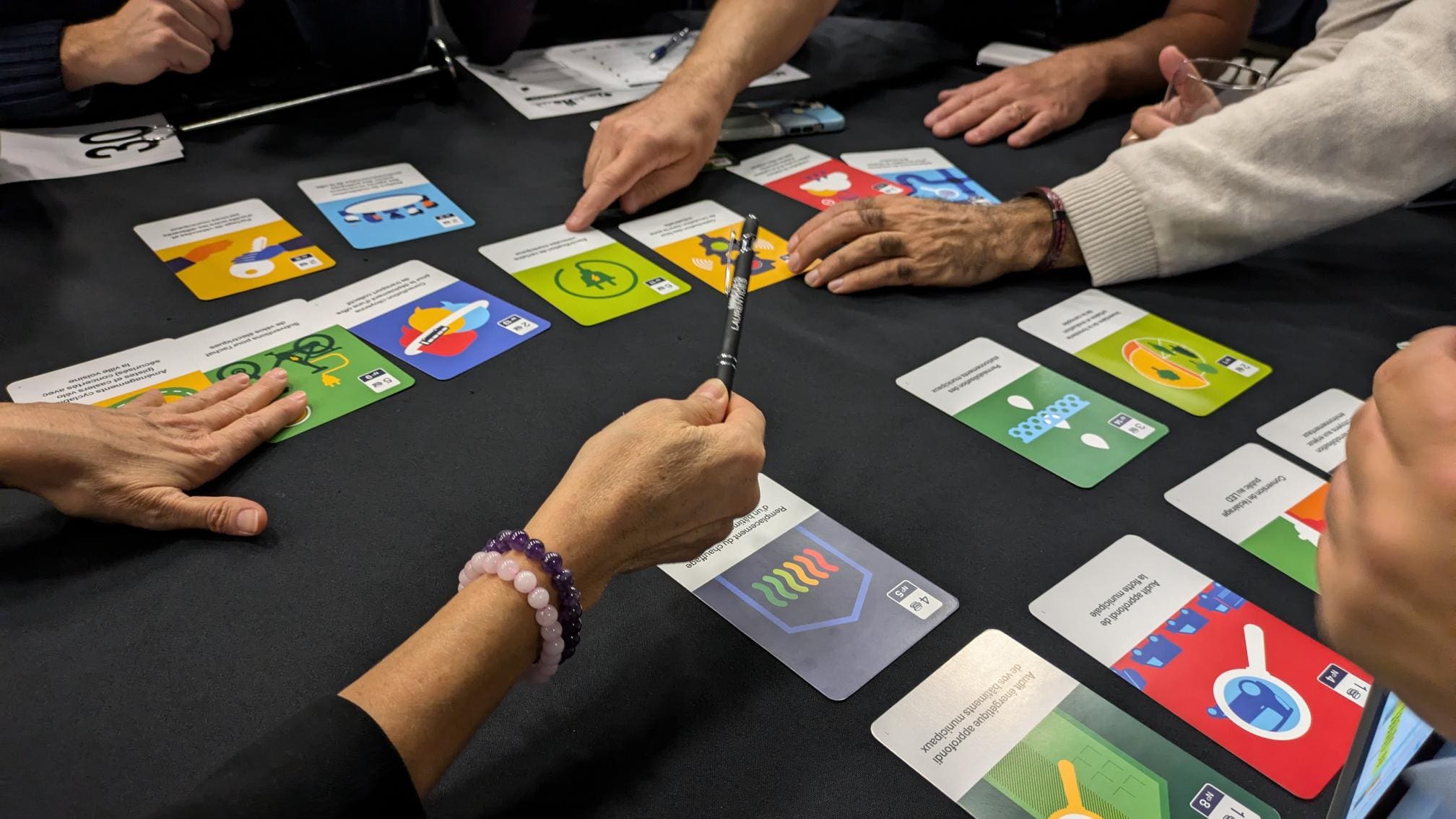 "Un groupe réuni autour d'une table est absorbé par le jeu Municipia