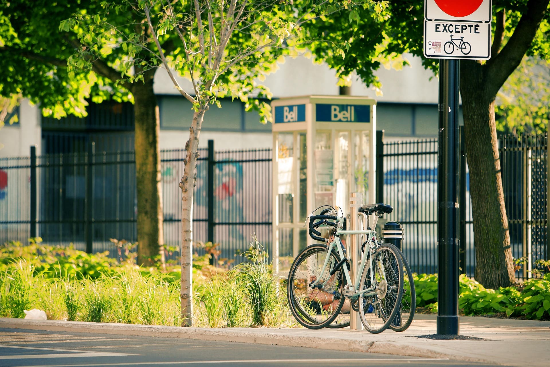 Cabine téléphone devant une cour d'école de Montréal avec un vélo stationné