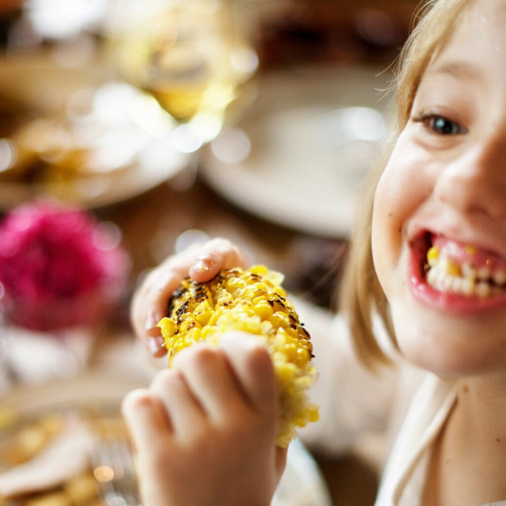 Une enfant mange du blé d'inde